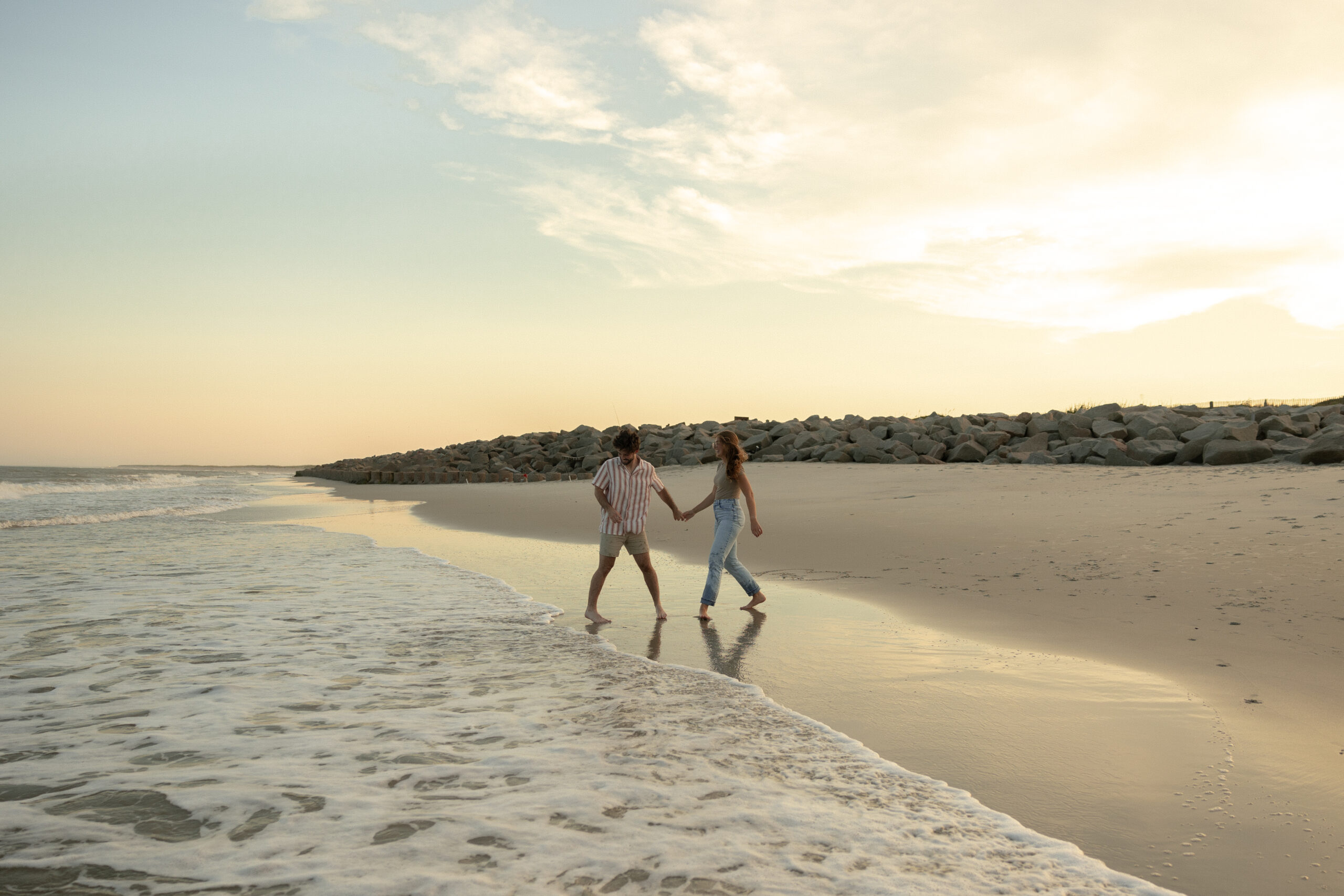 Couple running on beach in Wilmington, NC