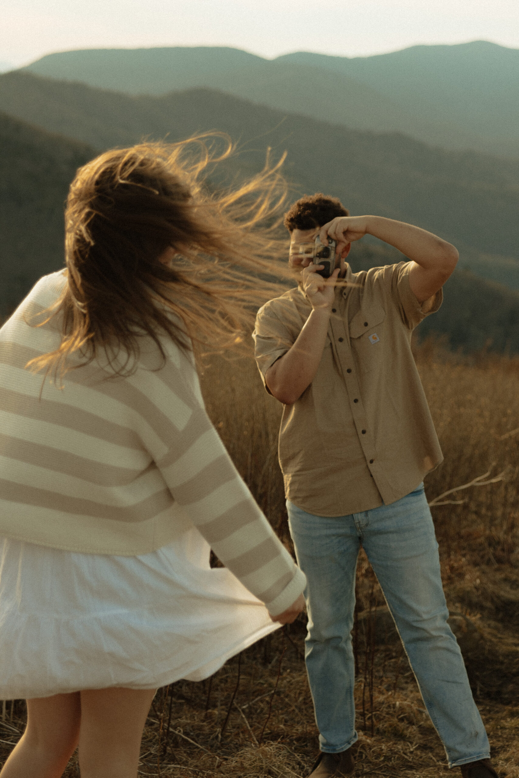Couple taking film photos of one another in Blue Ridge Mountains